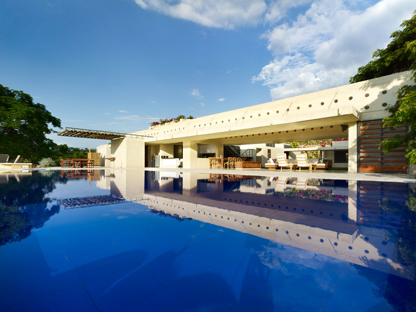 La piscina se encuentra en el borde occidental de la zona social y el agua se mantiene a una temperatura que oscila entre los 27 y los 30 grados durante todo el año, pues recibe sol constantemente y es poco profunda. Fotografía: cortesía, Premios Obras CEMEX Colombia 2016.
