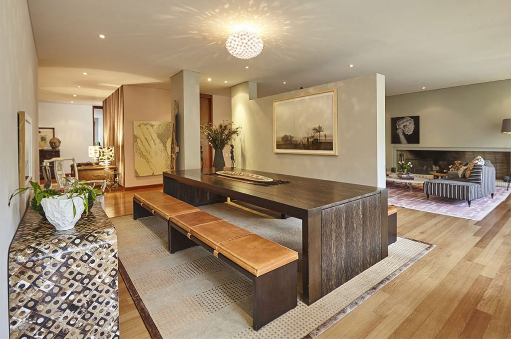 A la izquierda, sobre el mesón de cacho de William Piedrahita, cuadro de Miguel Ángel Rojas. Al fondo, silla china, de Kambora. A la derecha, cuadro de Rodrigo Facundo. Sobre la mesa, pieza del Amazonas, de werregue y madera. Fotografía: Gabriel Lugo.