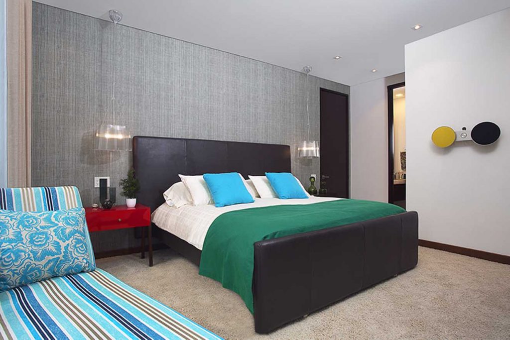 El mobiliario del dormitorio principal fue diseñado y fabricado por Gina Ríos. Las telas son de la firma Designers Guild, adquiridas en Denise Webb. Se destacan el espaldar de cuero chocolate, las lámparas suspendidas de Kartell y el papel de colgadura de la firma francesa Élitis, de Michel Editores. Fotografía: Luis Fernando Ramos.