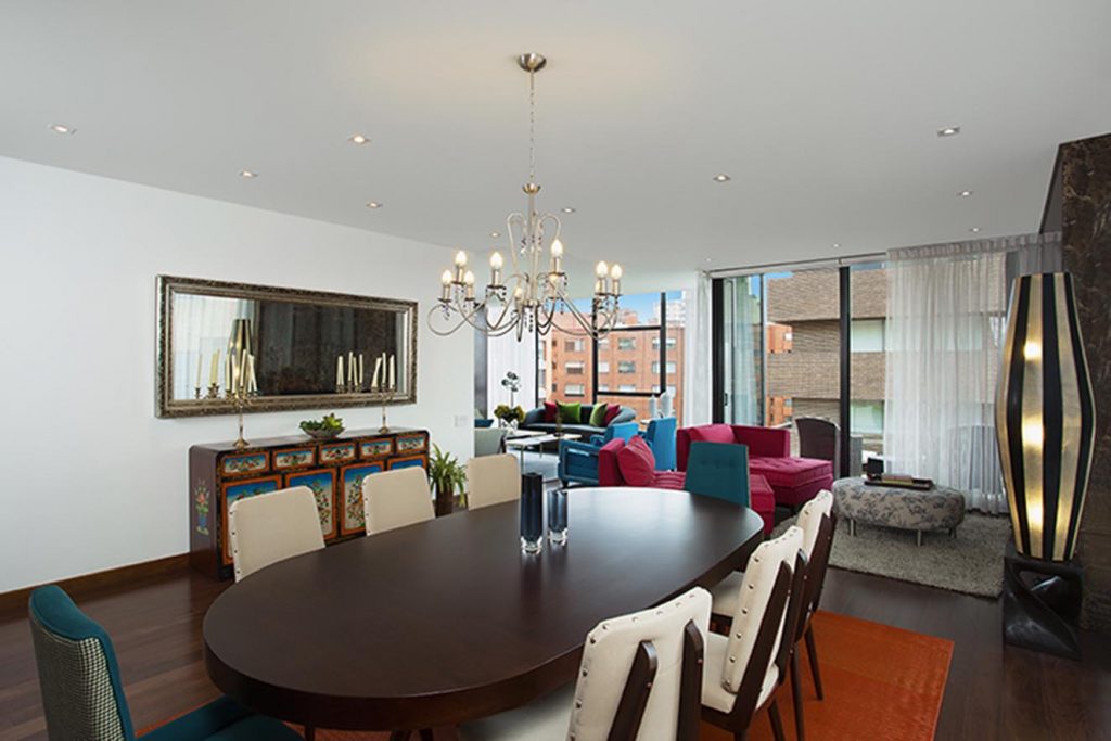 Vista desde el comedor hacia el salón. Los propietarios incluyeron piezas que poseían con anterioridad, como las lámparas, la consola china y el espejo.Fotografía: Luis Fernando Ramos.