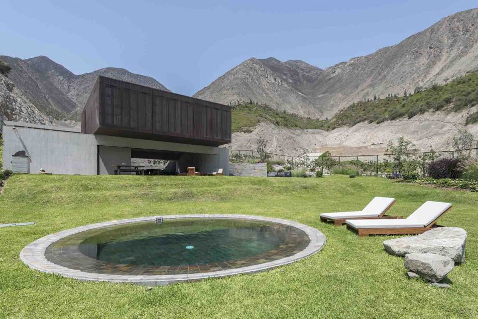 ista desde el jardín con piscina a la casa. Los materiales empleados en su construcción siguen las tonalidades de la geografía con el fin de que se mimetice con el paisaje. Fotografía: Renzo Rebagliati.