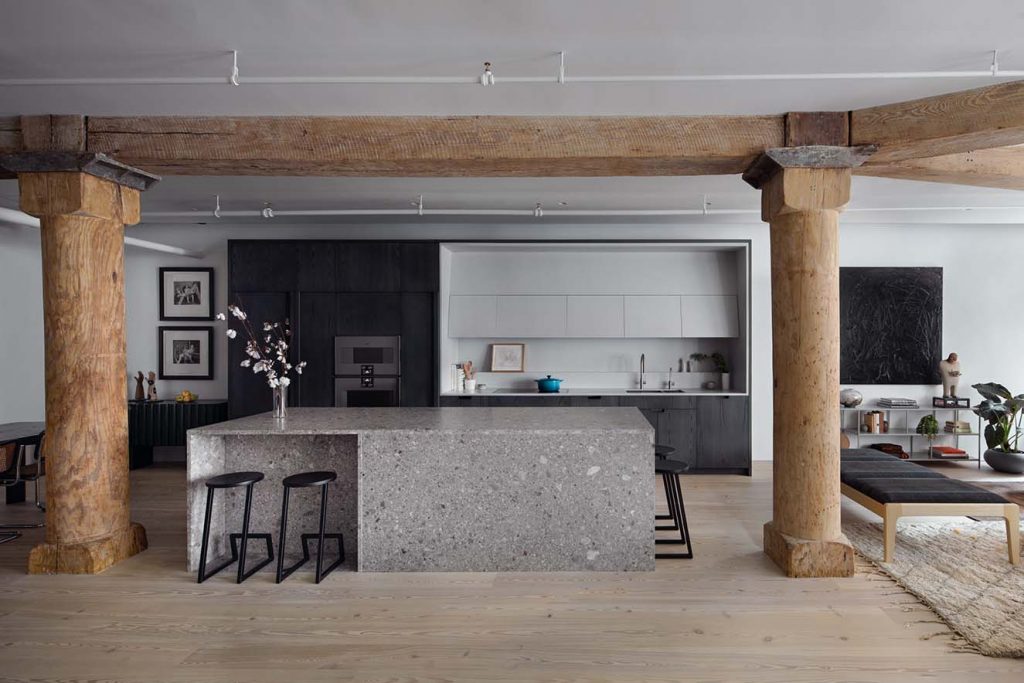 La cocina, el corazón del loft, completamente abierta al área social cuenta con una isla monolítica de Ceppo de Gre (pavimento gres porcelánico efecto piedra). Los muebles, fabricados a la medida son de chapilla de fresno tono ceniza. El mesón y los lavaplatos son de Corian. Las bancas en la isla son de Hollis and Morris Corktown. Fotografía: Eric Petschek, cortesía Worrel Yeung.