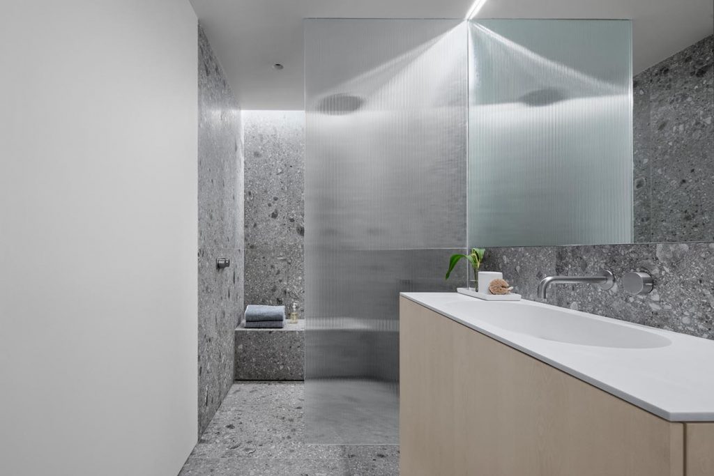 El baño principal replica el mismo material Ceppo di Gre usado en la isla de la cocina. Los muebles son de chapilla de fresno pintada de blanco. Fotografía: Eric Petschek, cortesía Worrel Yeung.