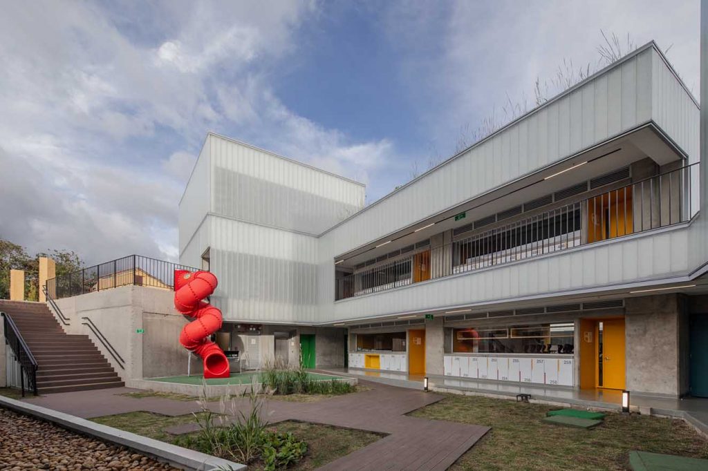 Colegio Helvetia. Vista del nivel inferior. Un rodadero rojo es uno de los elementos lúdicos  del proyecto.