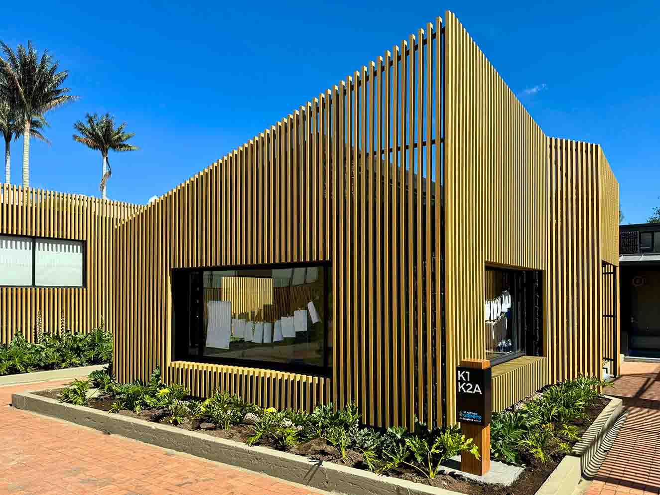 La nueva fachada en Ecowood, de Argos, se sobrepuso a los muros de concreto que se pintaron de negro. Fotografía: Yvonne Meyer.