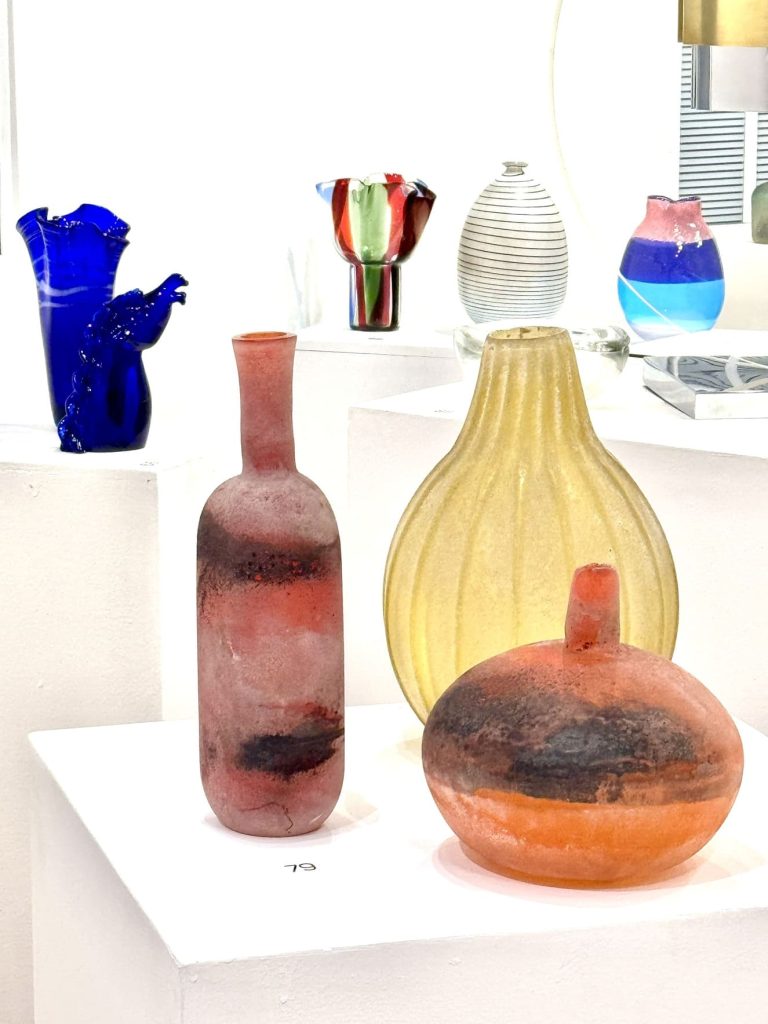 En primer plano, dos jarrones Cenedese (tono tierra), y el amarillo, jarrón de Archimede Seguso. Fotografía: Y. Meyer.