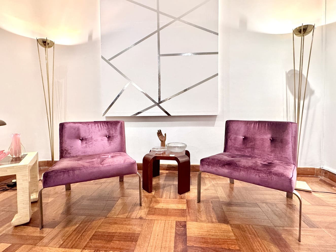 Poltronas vintage retapizadas, a la izquierda se aprecia una mesita auxiliar blanca de William Piedrahita, a los laterales, lámparas de pie "Atómico", de Relux Milán, y al centro, mesa auxiliar art déco. Fotografía: Y. Meyer