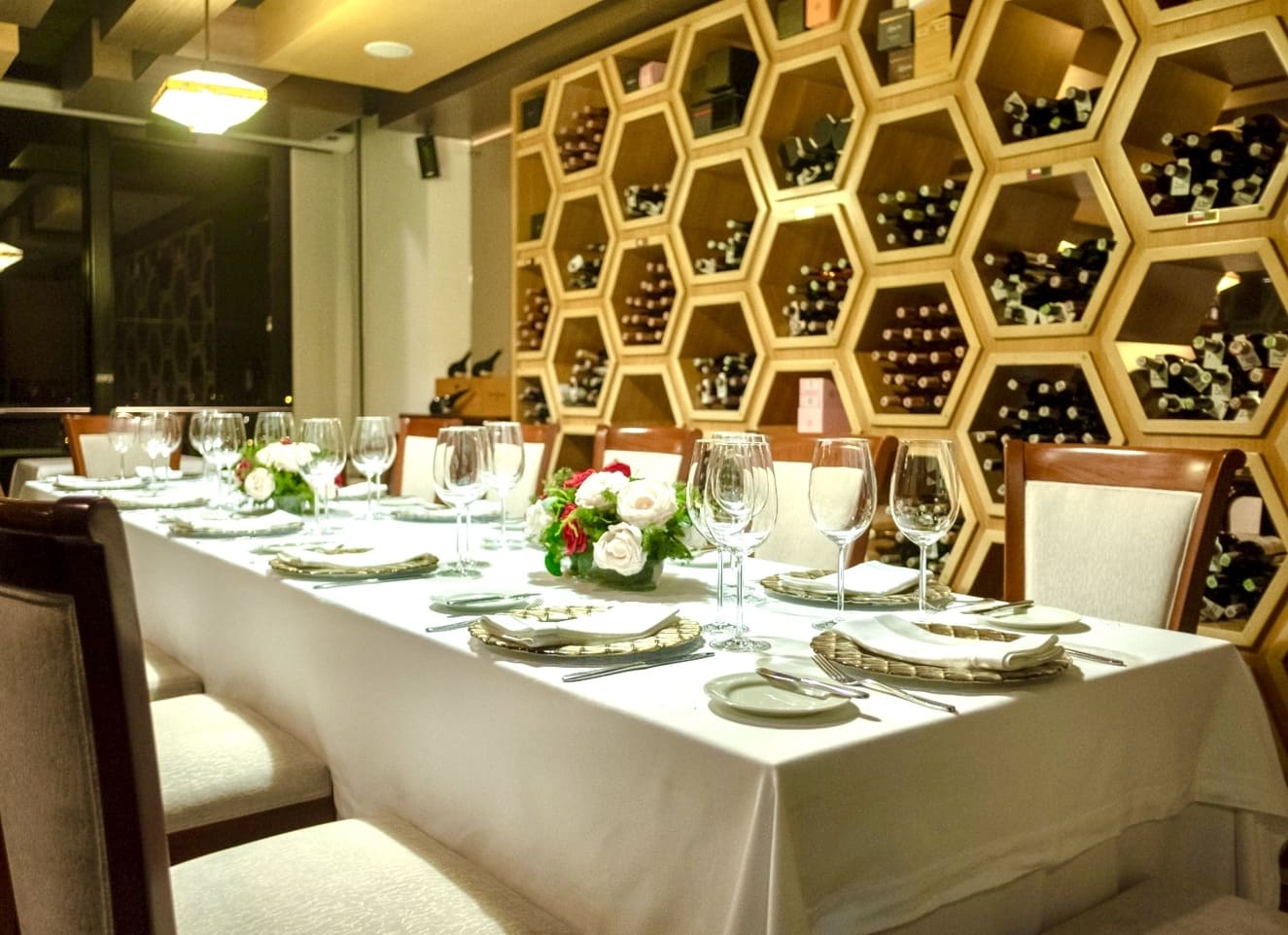 La cava se convierte en una de las piezas arquitectónicas más llamativas de Galenos. Su estructura hexagonal, inspirada en los panales de abeja, combina estética y funcionalidad: cada módulo organiza las botellas de manera eficiente mientras crea un juego visual que invita a descubrir la colección de vinos. Fotografía: cortesía Galenos.